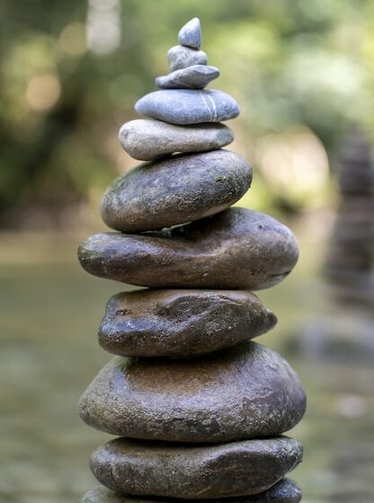 gros-plan-vertical-pyramide-pierres-equilibre-eau-riviere_181624-46093